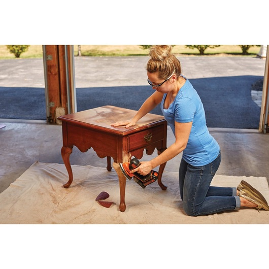 Corded drill / driver and mouse detail sander combo kit being used by a person to refinish furniture.
