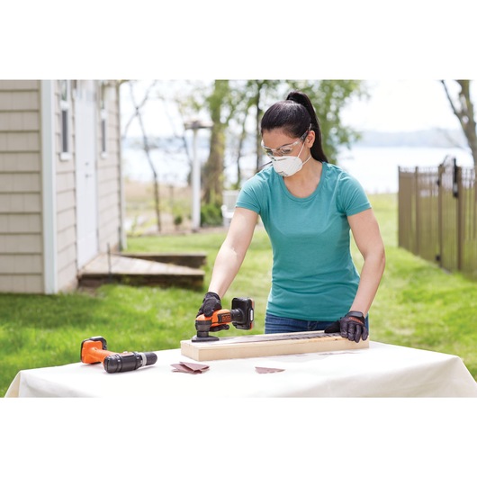 GoPak 4 tool combo kit being used by a person to sand wood outdoors.