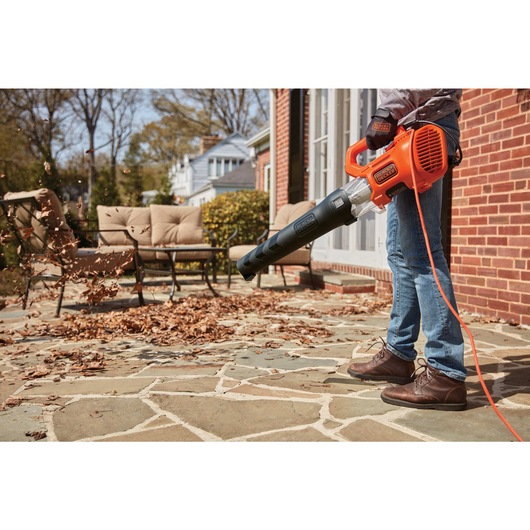 9 amp electric axial leaf blower being used to blow leaves off the house foyer.