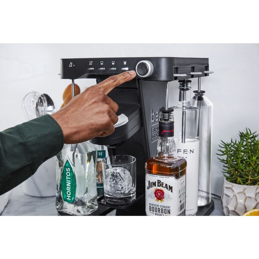 close-up, in the kitchen, of a man's hand pressing the mix button on the bev by BLACK+DECKER™ cocktail maker