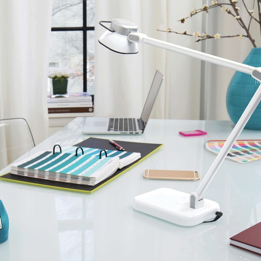 Elate Dual Arm L E D Desk Lamp placed at office table.